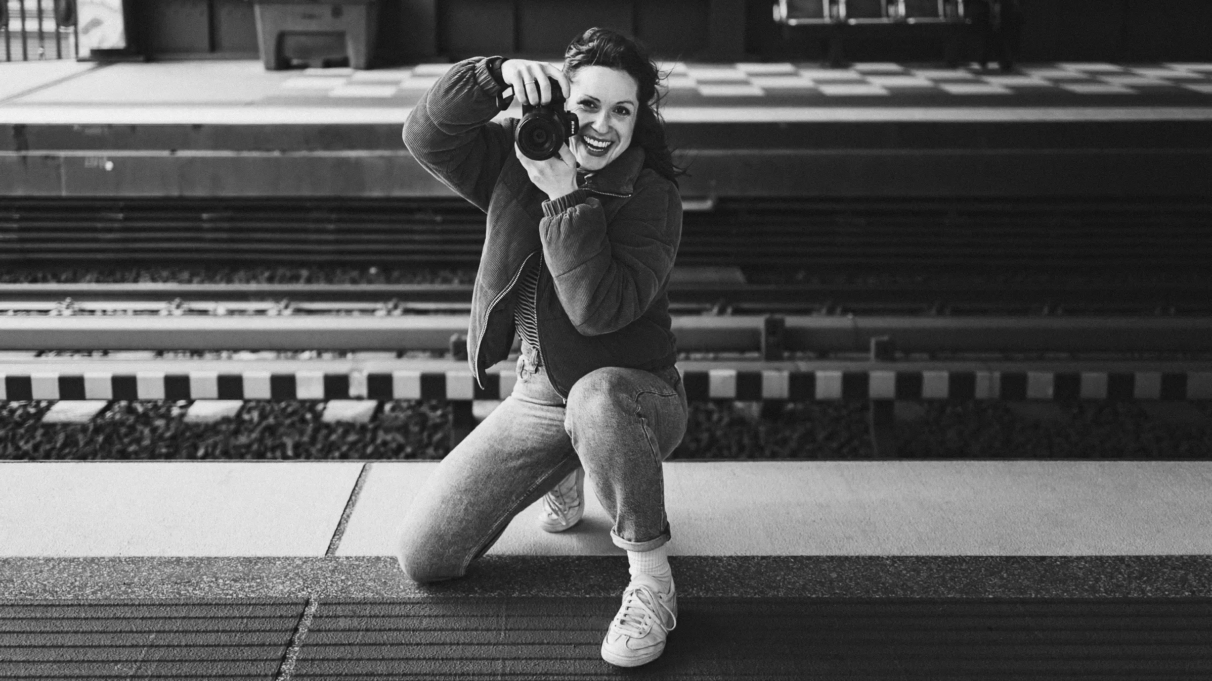 Ulrike mit Kamera auf einem Bahnsteig